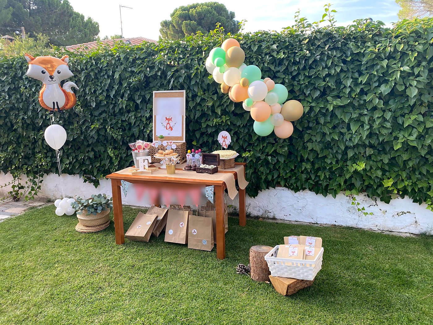 Cumpleaños infantil en el jardín, con la mesa de dulces junto al seto